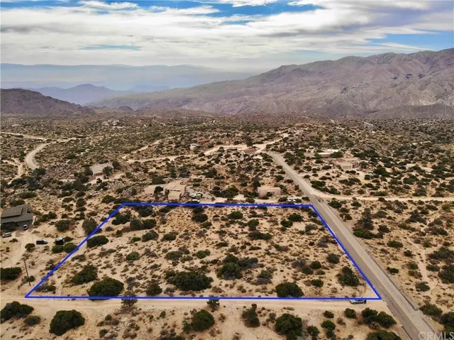 a view of a mountain in the distance in a field