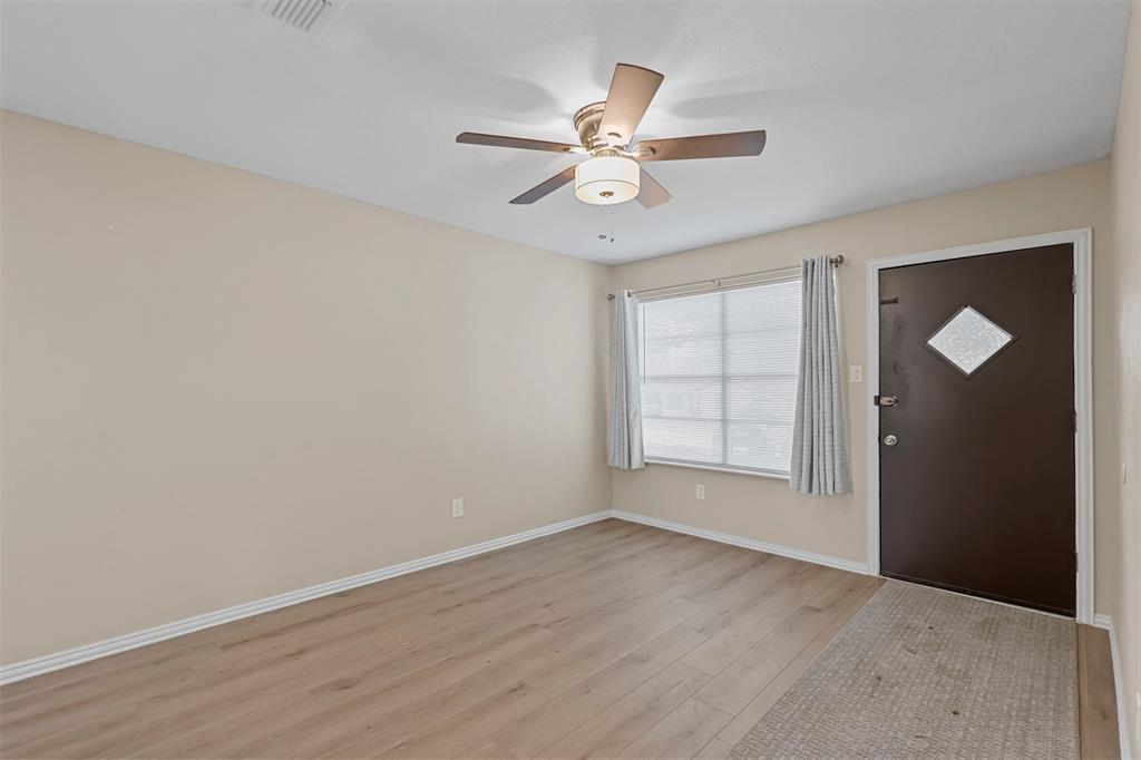 2801 Skyline Drive, Unit A Sansom Park, TX 76114 - Photo 3 of 16 an empty room with wooden floor fan and windows