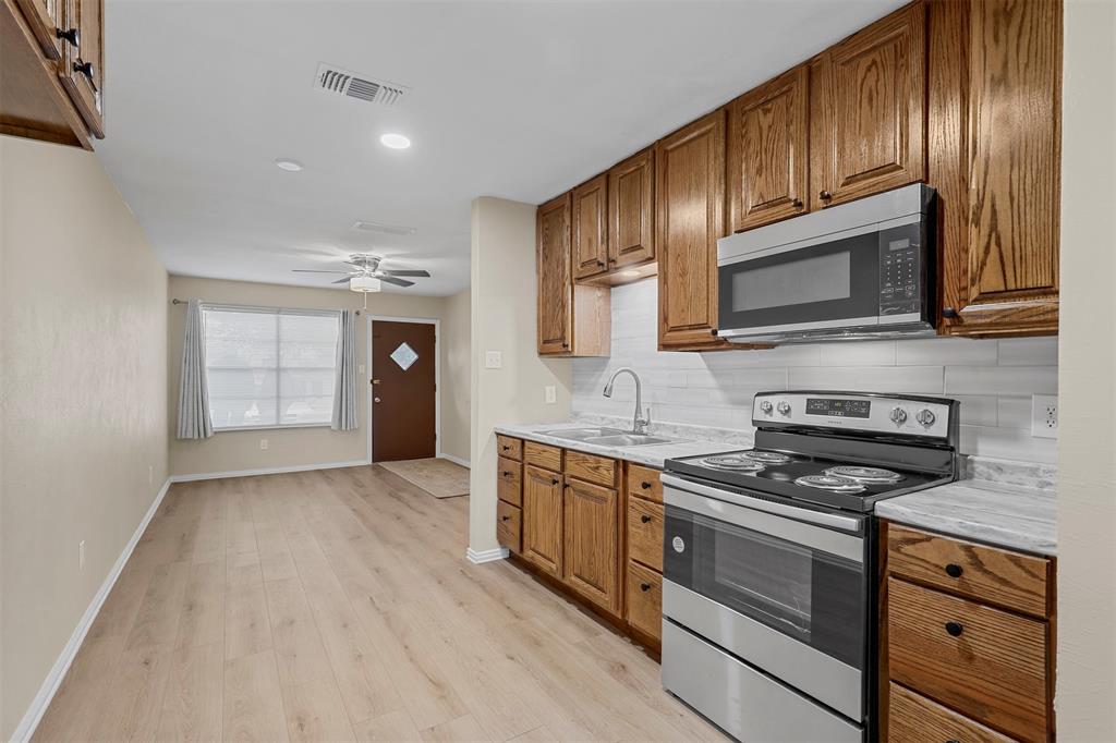 2801 Skyline Drive, Unit A Sansom Park, TX 76114 - Photo 6 of 16 a kitchen with granite countertop wooden cabinets stainless steel appliances and a sink