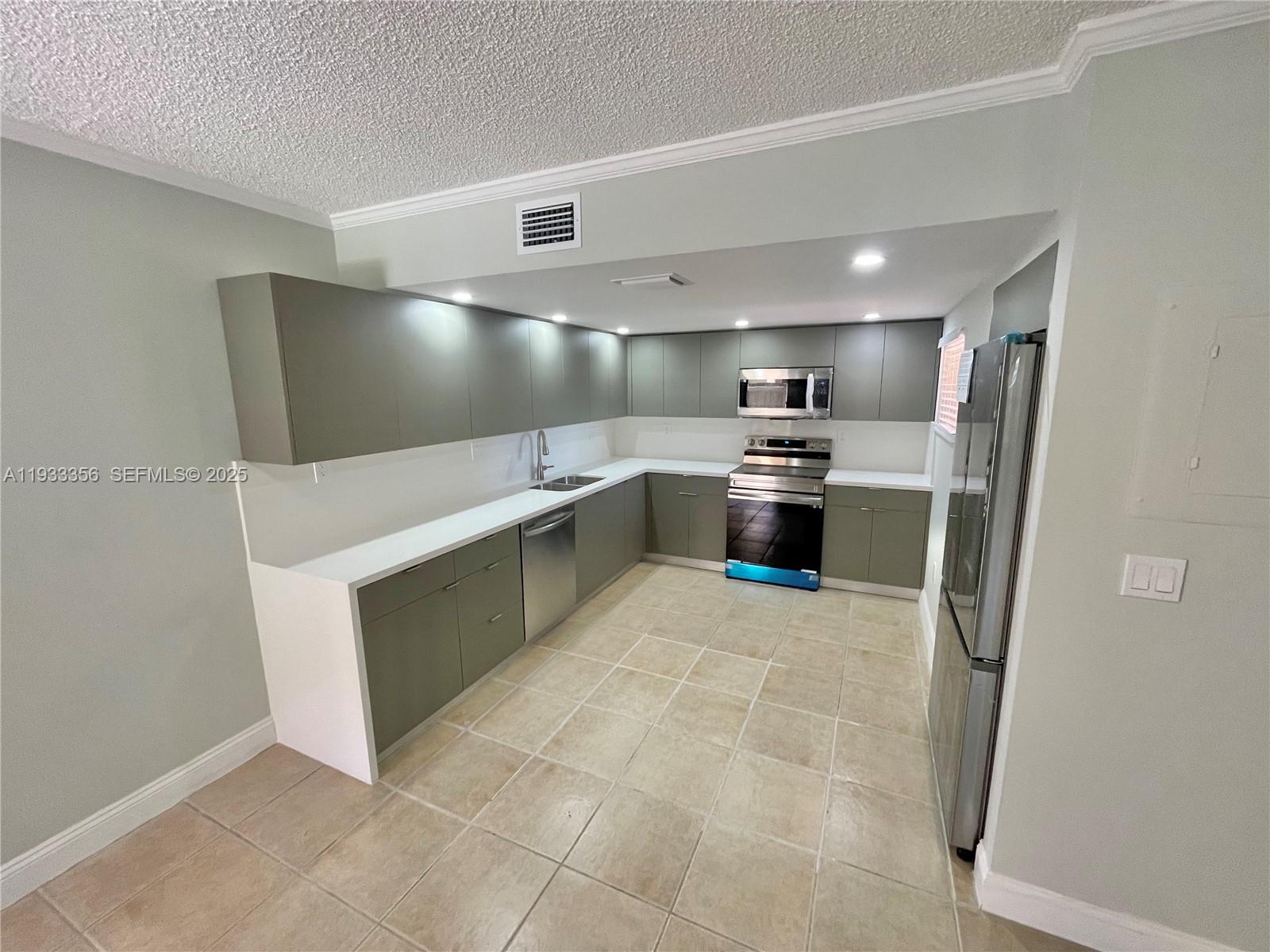 10897 Northwest 7th Street, Unit 1429 Miami, FL 33172 - Photo 2 of 17 a kitchen with refrigerator and microwave