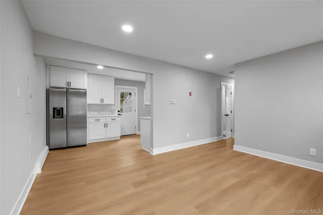 a view of a kitchen with refrigerator and windows