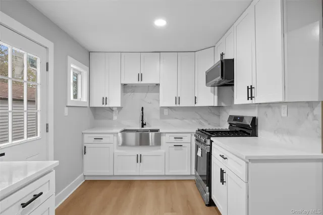 a kitchen with white cabinets stainless steel appliances and sink