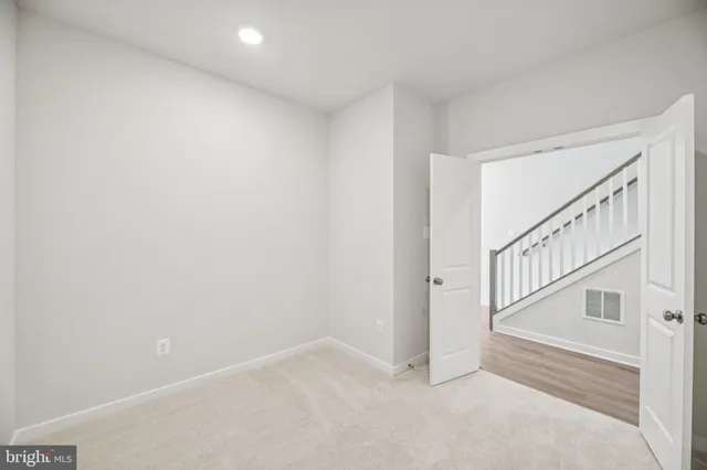 a living room with furniture a bookshelf and a window