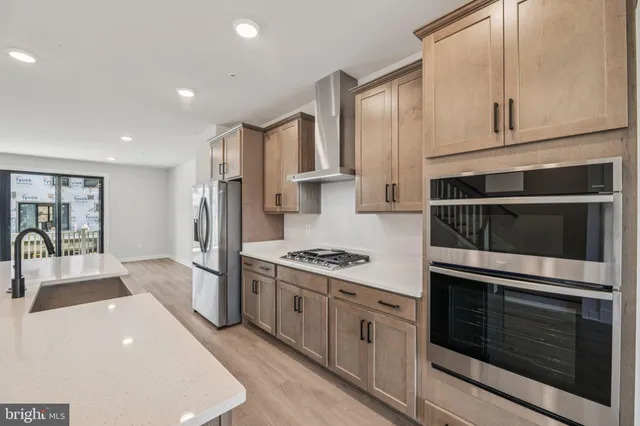 a kitchen with stainless steel appliances granite countertop a stove a sink and a refrigerator