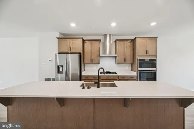 a kitchen with stainless steel appliances a sink stove and refrigerator