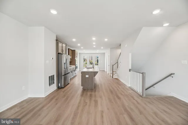 a view of open kitchen with wooden floor and a refrigerator