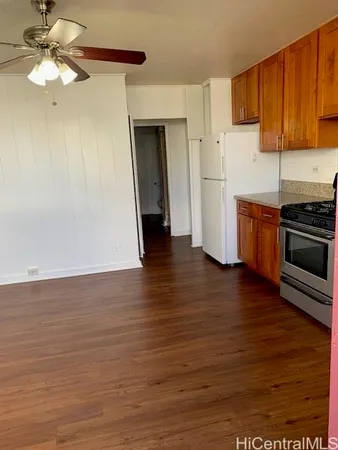 a kitchen with stainless steel appliances granite countertop a refrigerator a stove and a wooden floors