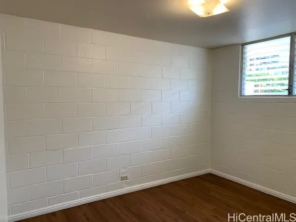 a view of a small space with wooden floor and a window