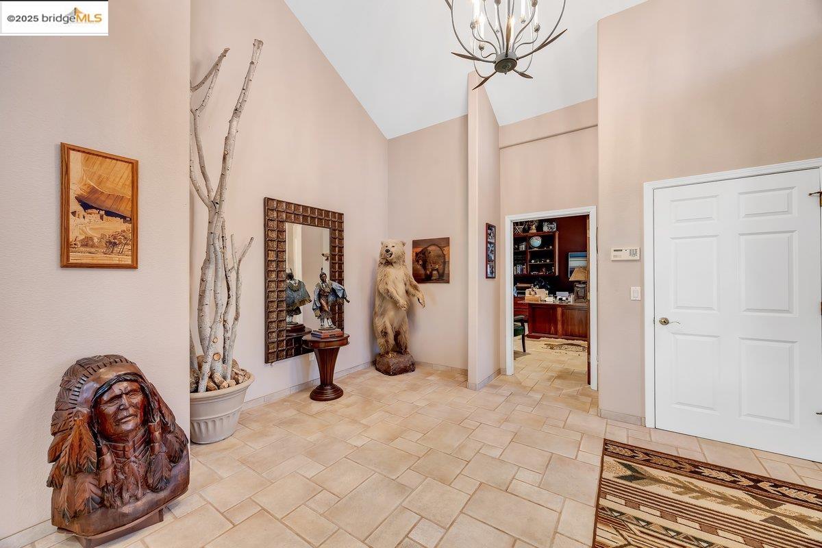 13700 Clements Road Groveland, CA 95321 - Photo 8 of 93 Entryway featuring high vaulted ceiling, a chandelier, and light stone finish floors