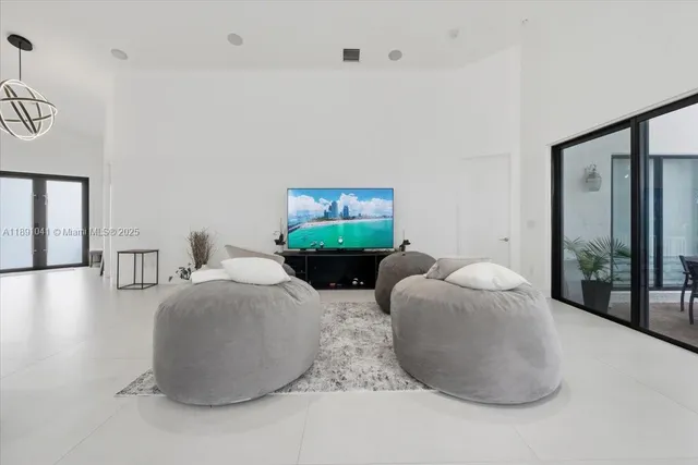 a living room with furniture a large window and a chandelier
