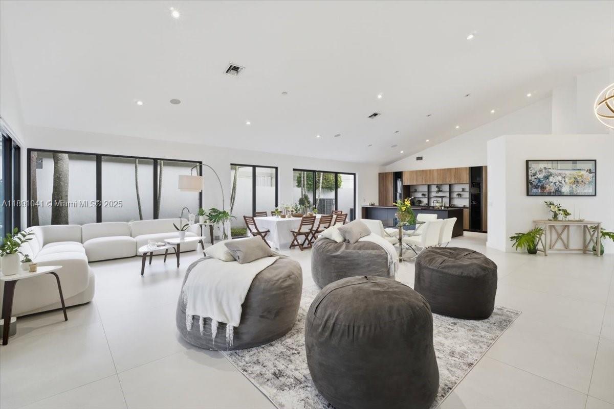 1441 154th Avenue Pembroke Pines, FL 33027 - Photo 12 of 37 a living room with furniture a large window and a chandelier