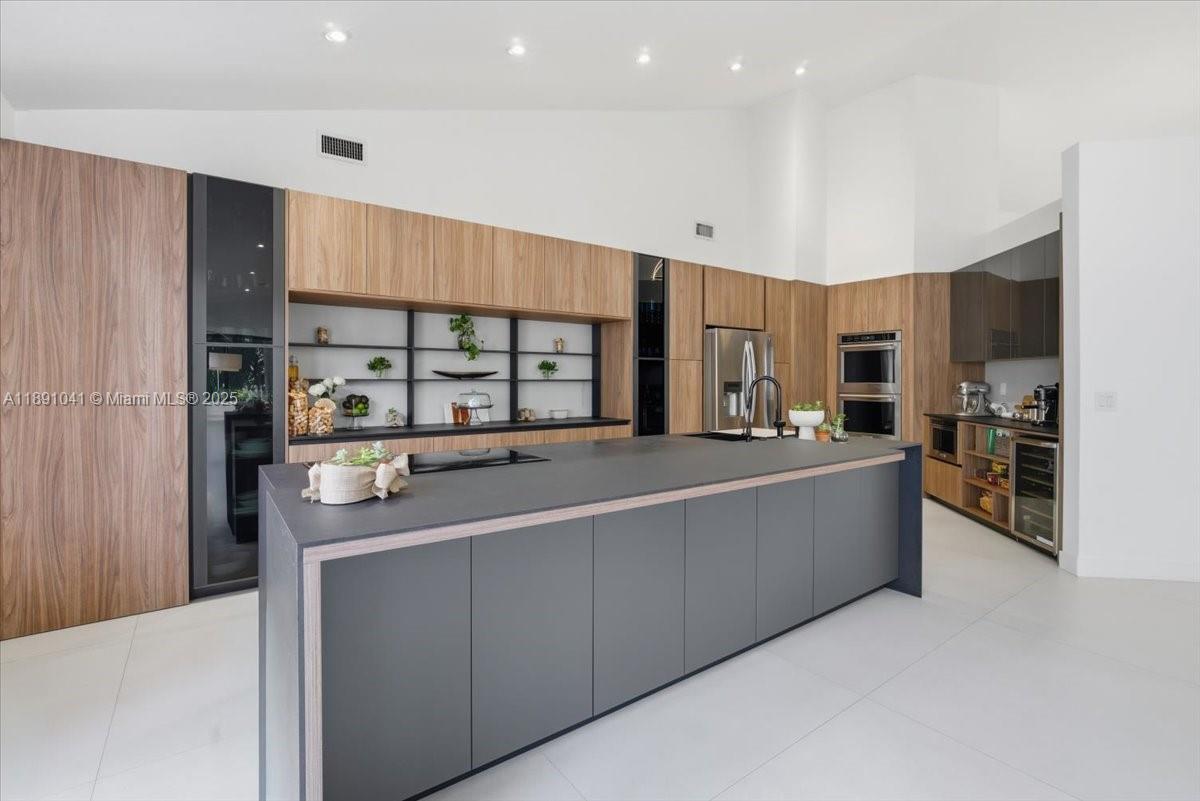 1441 154th Avenue Pembroke Pines, FL 33027 - Photo 14 of 37 a large kitchen with stainless steel appliances a large counter top a stove and a refrigerator