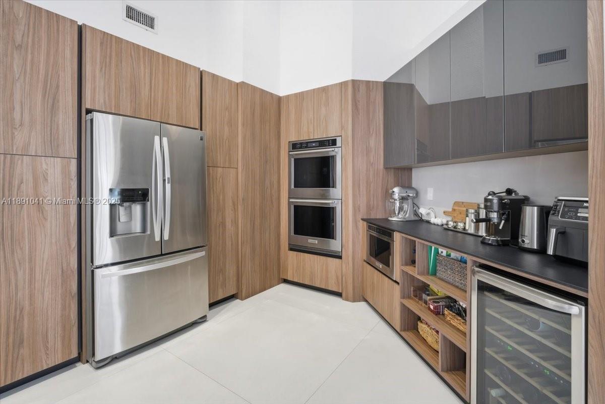 1441 154th Avenue Pembroke Pines, FL 33027 - Photo 16 of 37 a kitchen with stainless steel appliances a refrigerator and a stove top oven