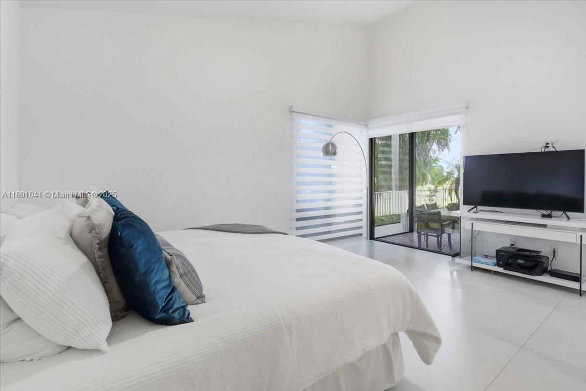 1441 154th Avenue Pembroke Pines, FL 33027 - Photo 19 of 37 a bedroom with a bed and a flat screen tv