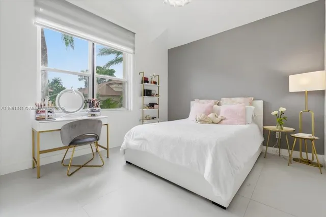 a bedroom with a bed tv and a chandelier