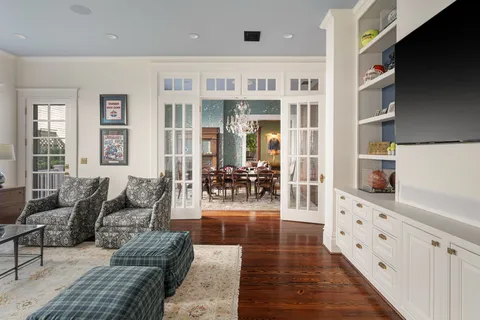 a living room with stainless steel appliances kitchen island granite countertop a wooden floor and cabinets