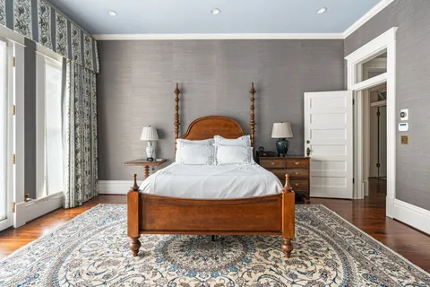 a bedroom with a bed and wooden floor