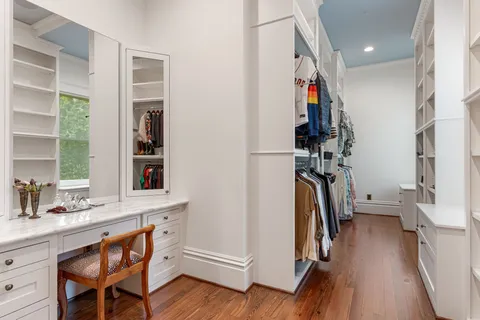a view of walk in closet with clothes and shoes