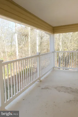 a view of a porch with wooden floor and fence