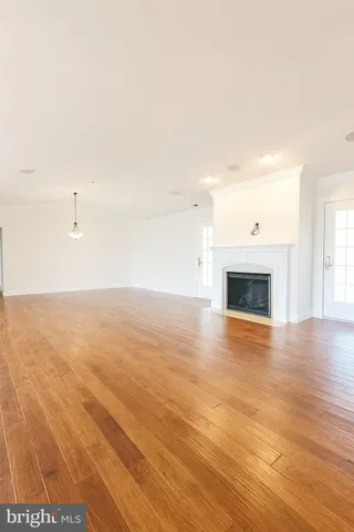 a view of empty room with wooden floor and fireplace