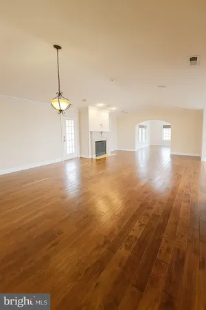 a view of a room with wooden floor staircase and a kitchen