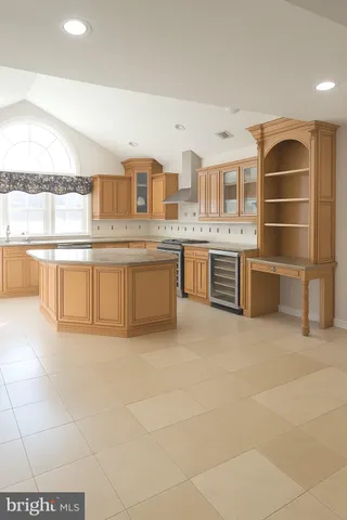 a large white kitchen with kitchen island a sink a stove a dining table and chair