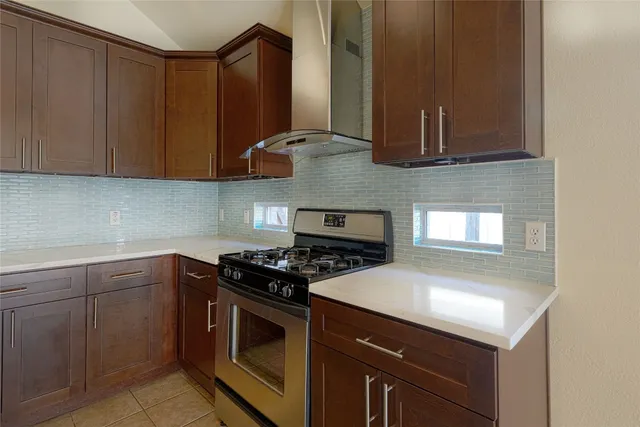 a kitchen with stainless steel appliances granite countertop a stove a sink and a microwave