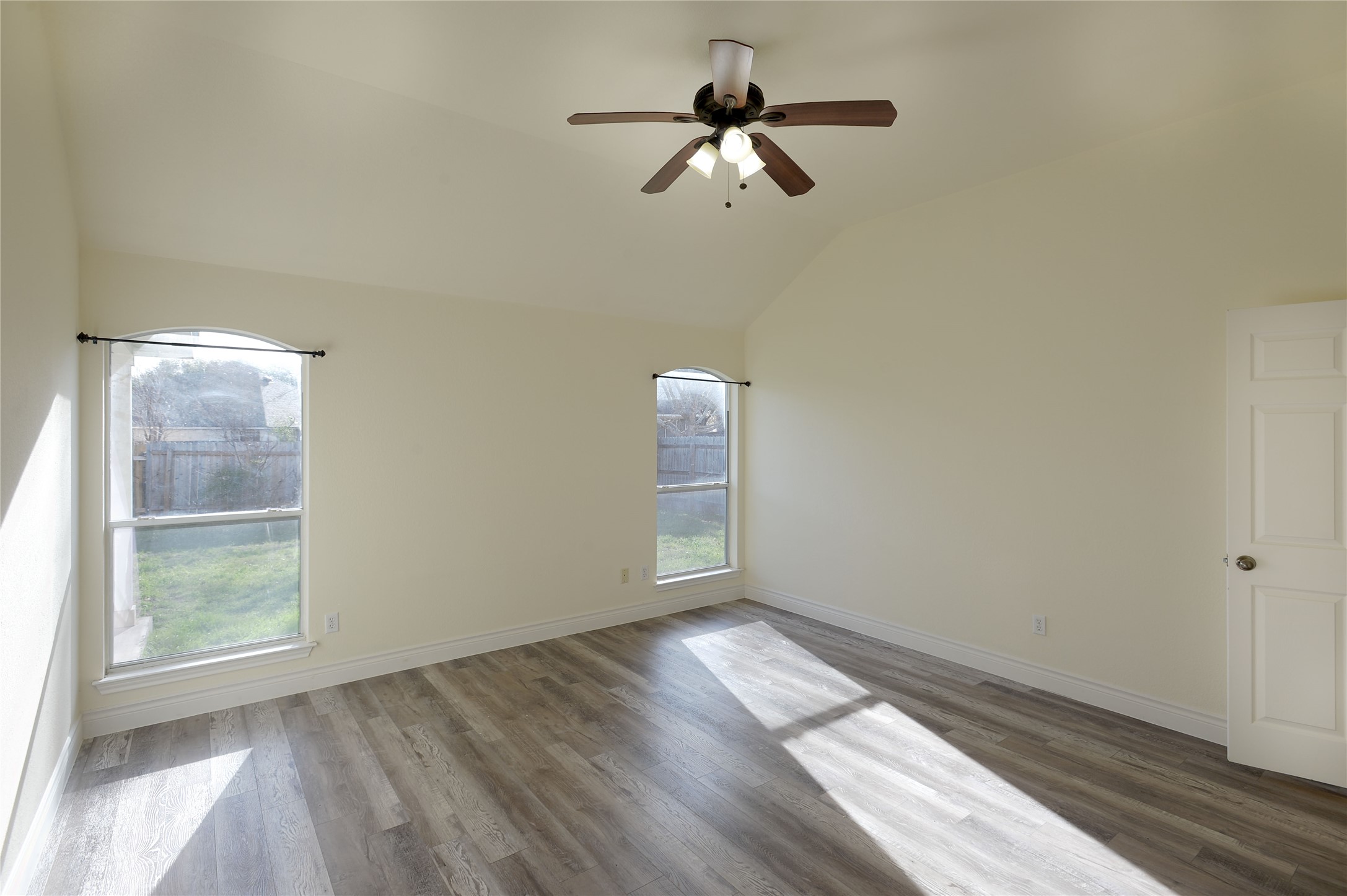 2129 Dry Tortugas Trail Austin, TX 78747 - Photo 23 of 38 an empty room with wooden floor fan and windows