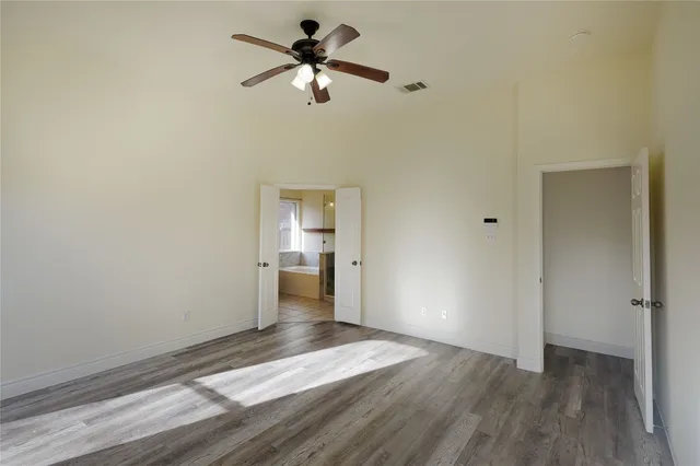 a view of a room with wooden floor and a ceiling fan
