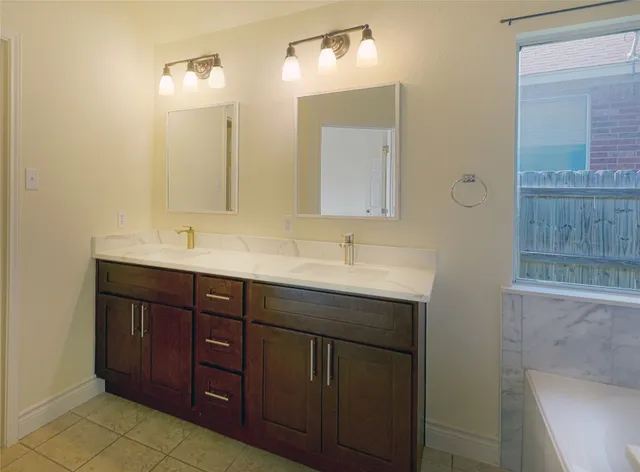 a bathroom with a double vanity sink and a mirror