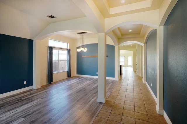 a view of a hallway with wooden floor and a bathroom