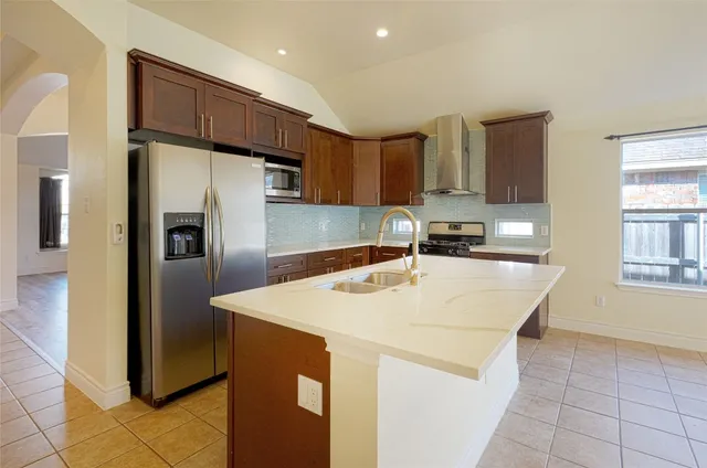 a kitchen with stainless steel appliances a refrigerator sink and stove