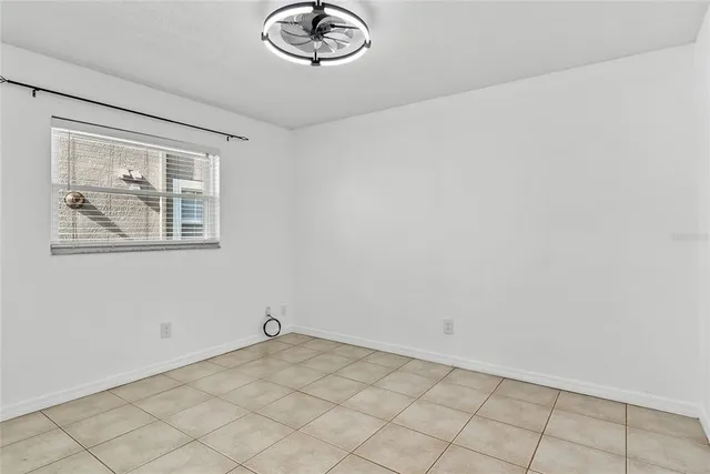 a view of a livingroom with a chandelier fan and windows