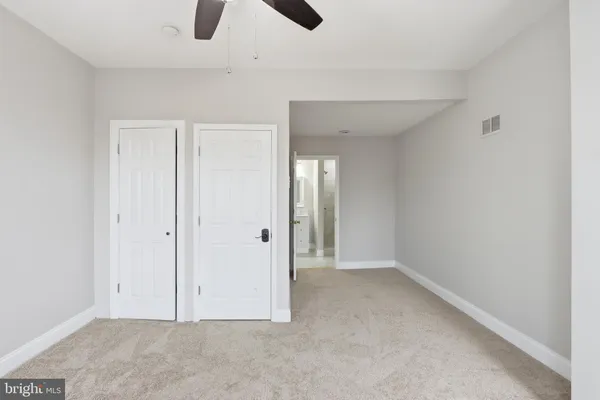 an empty room with a chandelier fan