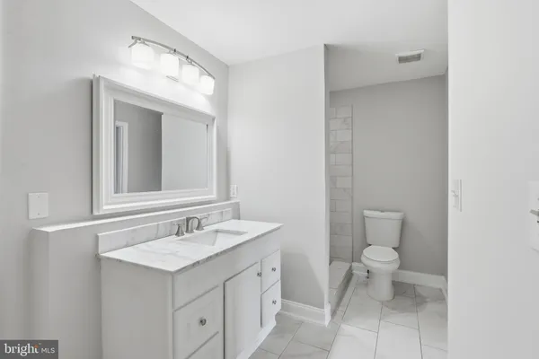 a bathroom with a sink a toilet and a mirror