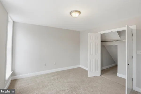 an empty room with windows and closet