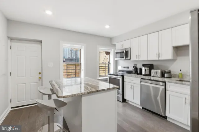 a kitchen with granite countertop white cabinets and white appliances
