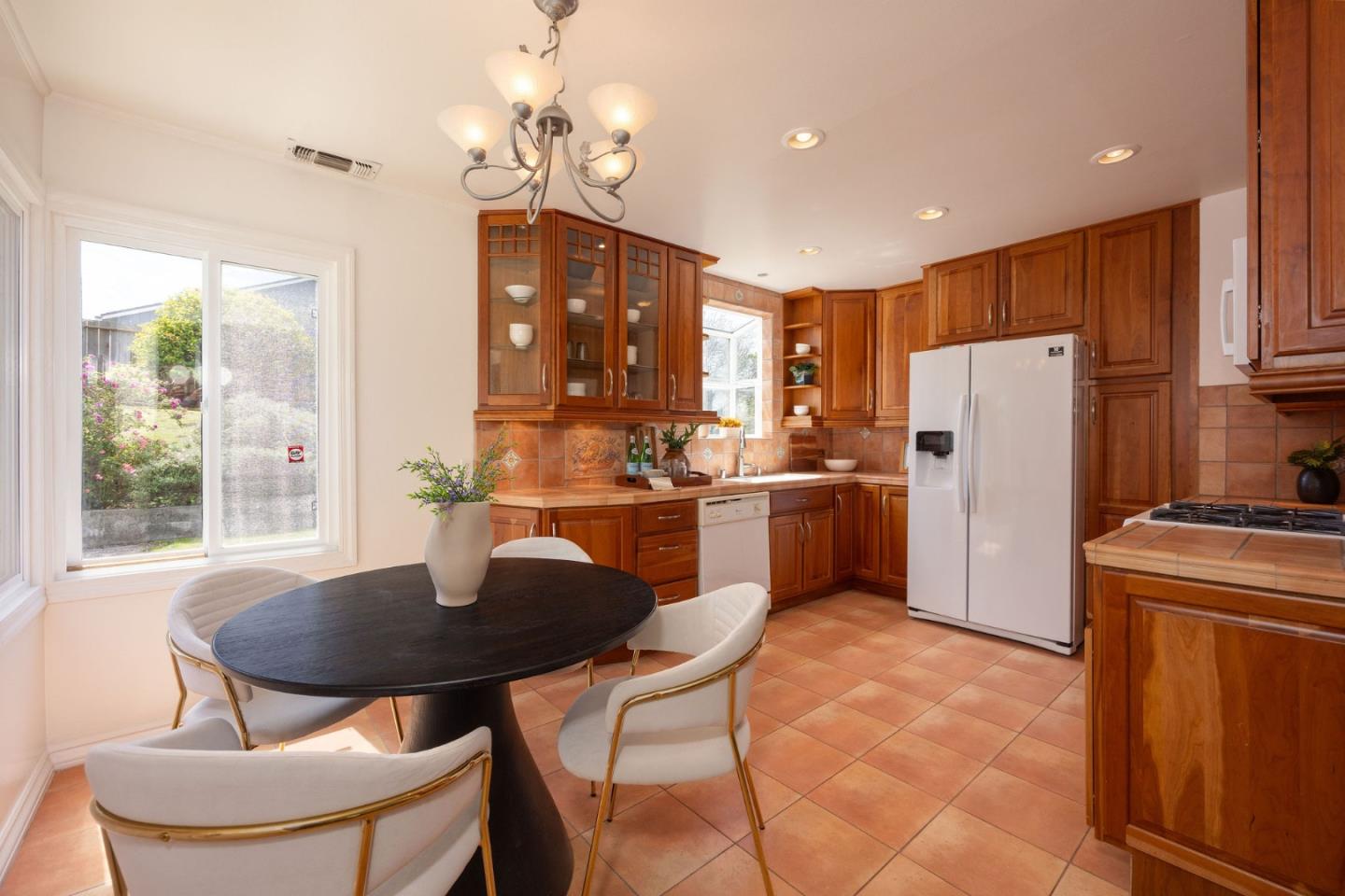 304 Nelson Avenue Pacifica, CA 94044 - Photo 14 of 39 a kitchen with stainless steel appliances a dining table chairs and a refrigerator