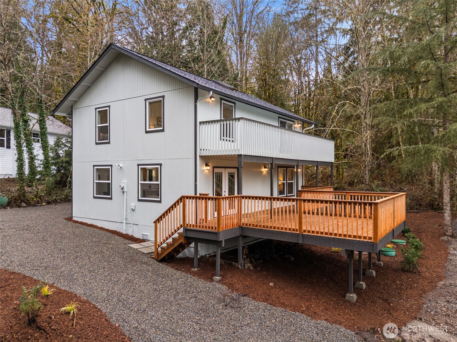 7605 Northeast Hidden Cove Road Bainbridge Island, WA 98110 - Photo 25 of 39 a view of a house with a yard wooden deck and a outdoor space