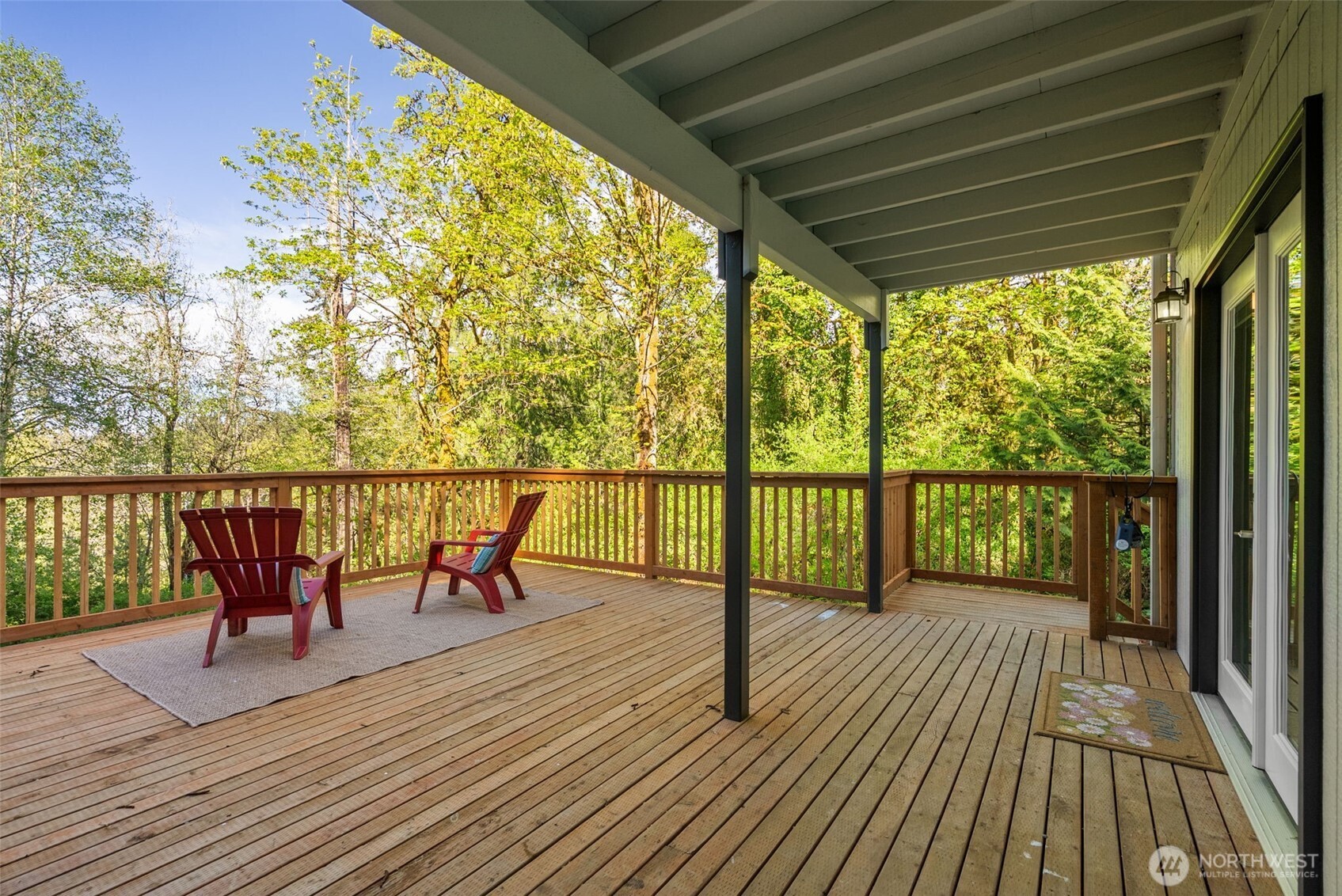 7605 Northeast Hidden Cove Road Bainbridge Island, WA 98110 - Photo 36 of 39 a view of a deck with wooden floor and outdoor seating