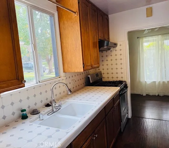 a kitchen with stainless steel appliances a stove a sink and a microwave