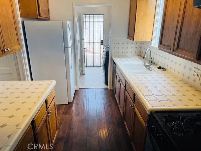 a kitchen with stainless steel appliances a refrigerator and wooden floor
