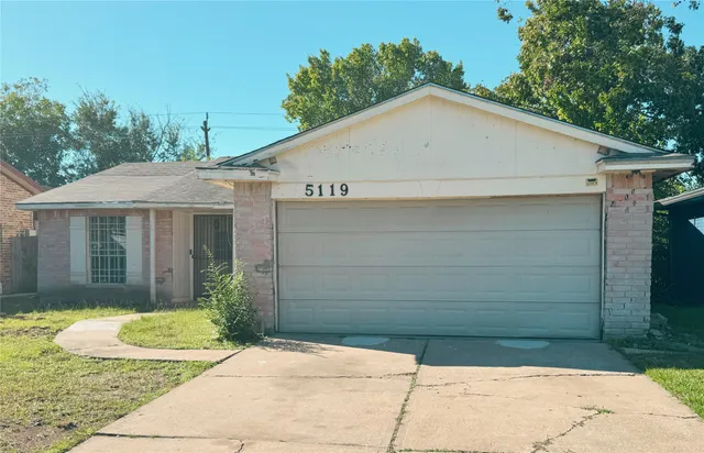 a view of a white house with a small yard and large window