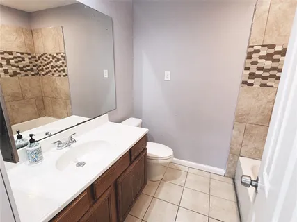 a backyard of a house with plants and large tree