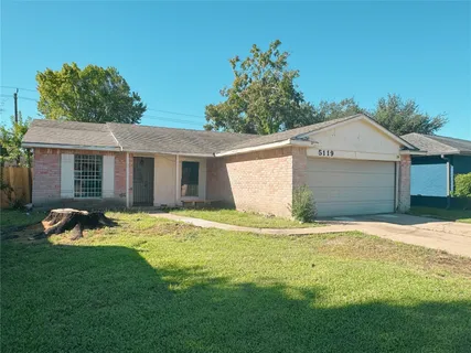 a front view of a house with a garden and yard