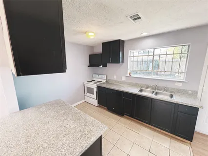 a kitchen with a sink window and refrigerator