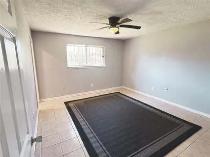 an empty room with chandelier fan