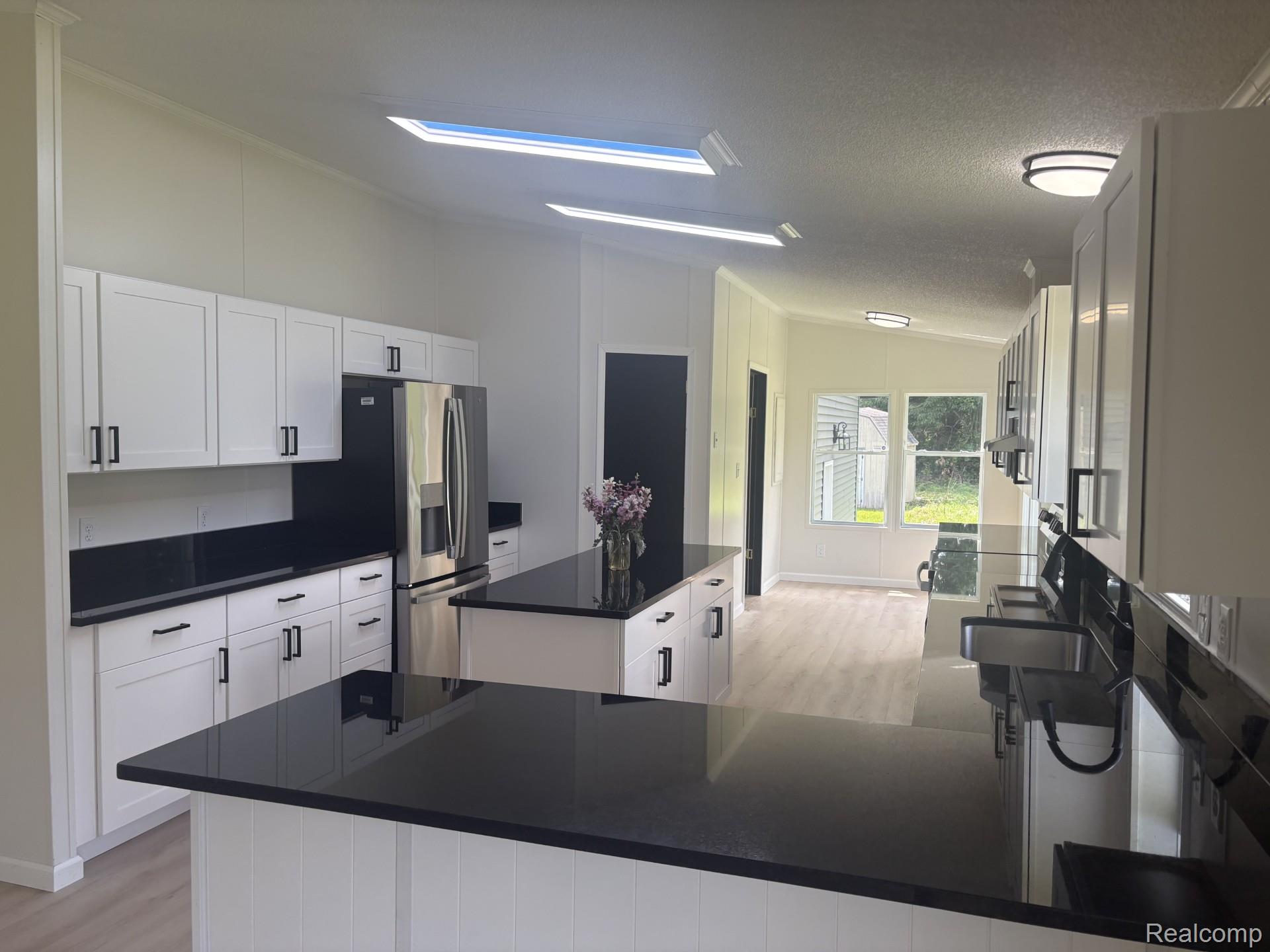 3586 Columbiaville Road Columbiaville, MI 48421 - Photo 3 of 10 Bright kitchen featuring white cabinetry, dark countertops, and stainless steel appliances