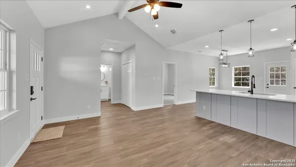 a kitchen with white cabinets stainless steel appliances and wooden floor