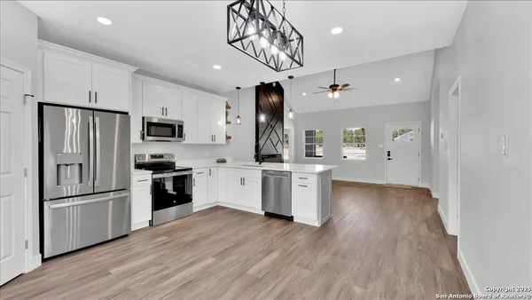 a kitchen with stainless steel appliances a refrigerator microwave and sink
